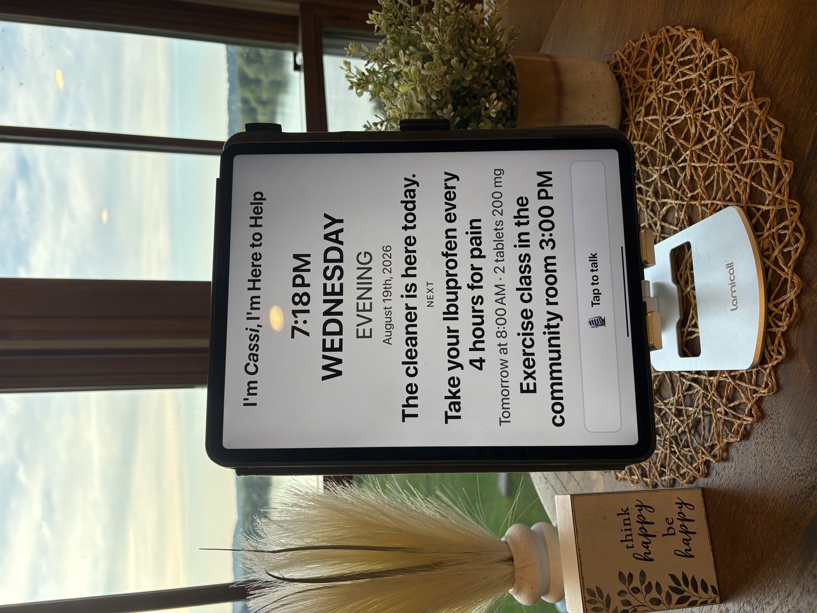 The Compasse board at dusk by a window, showing Wednesday evening with tomorrow's medication reminder queued